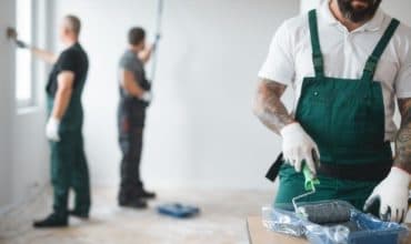 Decorator cutting in paint on a freshly prepared interior wall