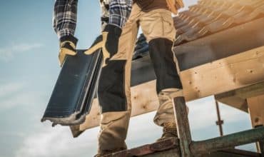 Roofer replacing slates on a pitched roof