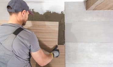 Tiler setting out wall tiles in a bathroom refurbishment